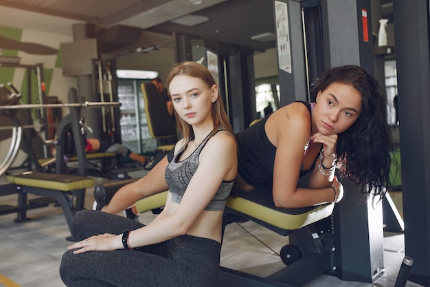 Beautiful girls in a gym. Sports ladies in a sportswear. Friends training