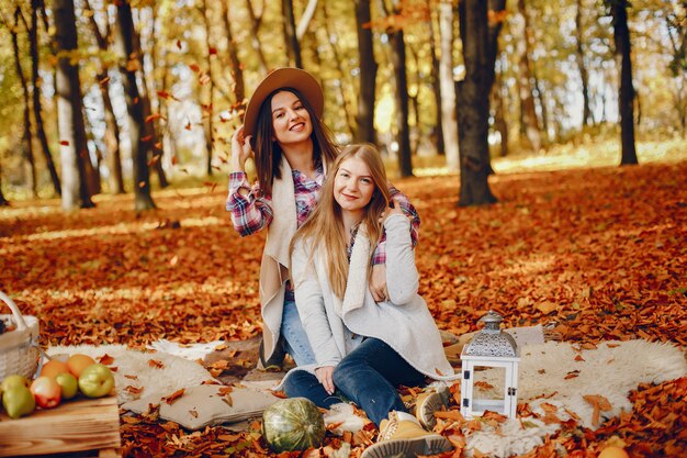 Beautiful girls have fun in a autumn park