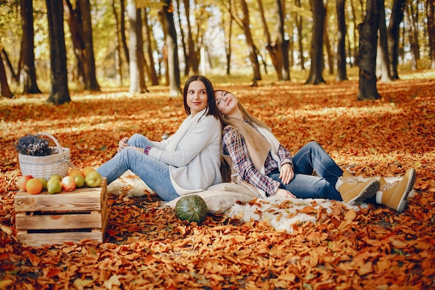 Le belle ragazze si divertono in un parco in autunno