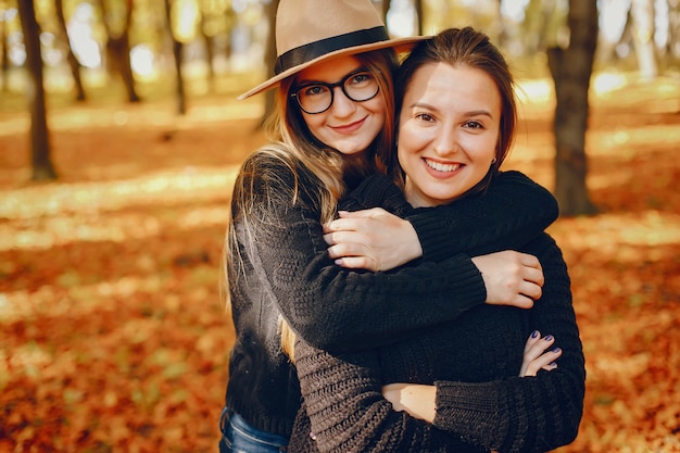 Le belle ragazze si divertono in un parco in autunno