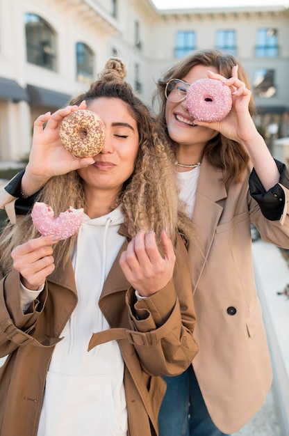 Free photo beautiful girls posing with delicious doughnuts