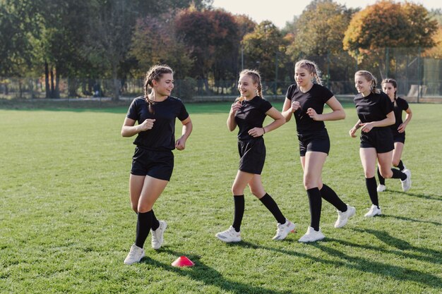 Beautiful girls running through cones