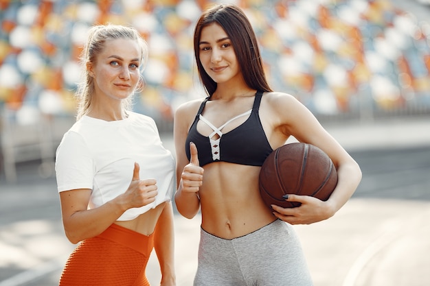 경기장에서 아름다운 소녀. 스포츠웨어의 스포츠 소녀. Baskettball 공을 가진 사람들.