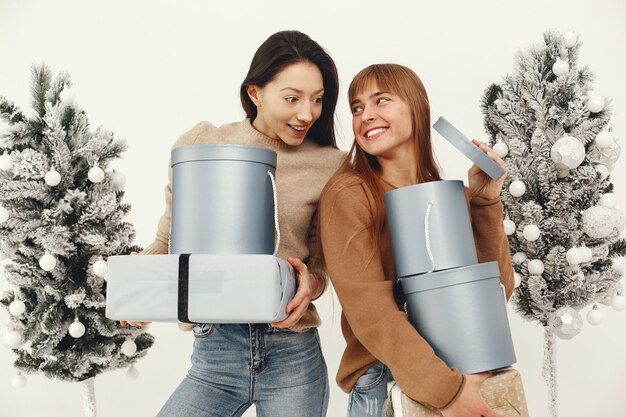 Beautiful girls standing in a studio with presents