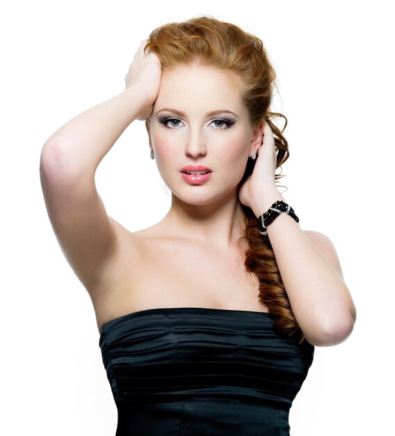 白い壁に分離された茶色の化粧品で美しいグラマー赤髪の女