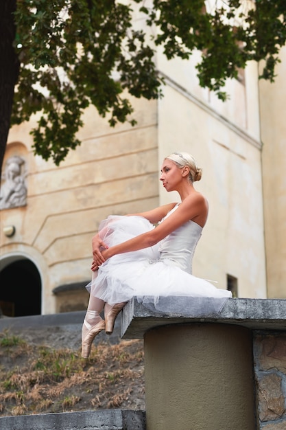 Beautiful graceful ballerina dancing on the streets of an old ci