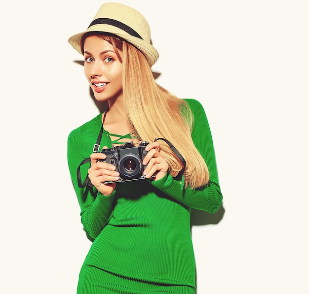 Free photo beautiful happy cute blond woman girl in casual summer green hipster clothes takes photos holding retro photographic camera