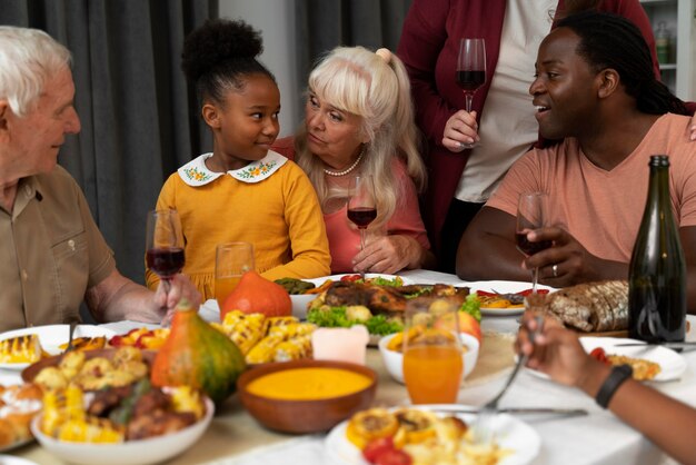 Красивая счастливая семья вместе обедает в честь Дня благодарения
