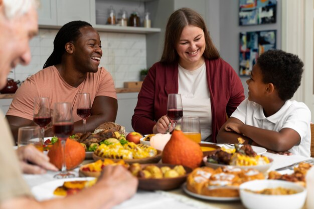 Красивая счастливая семья вместе обедает в честь Дня благодарения