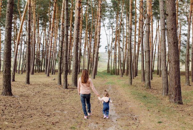 Beautiful and happy mother and daughter having a good time in the forest