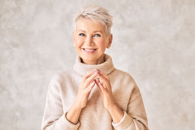 Free photo beautiful happy retired woman wearing cozy sweater and short hairdo