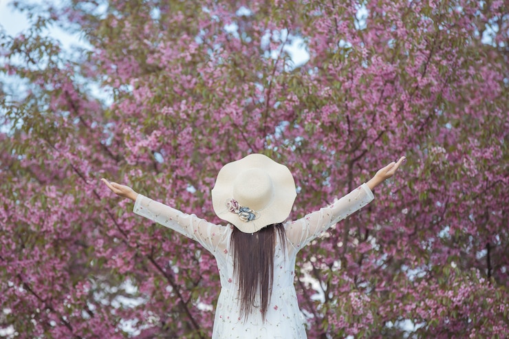 免費 Photo 一位美麗而快樂的女人站在外面, 開心地看着天空.