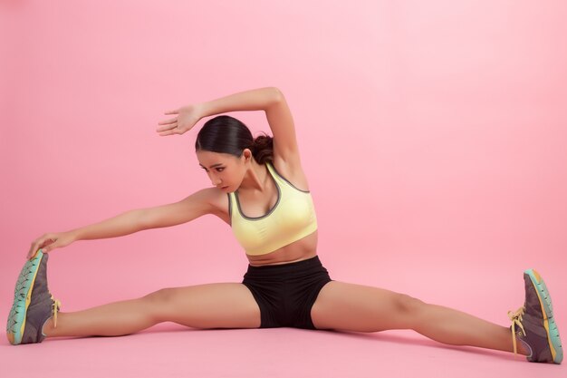 Beautiful healthy young Asian woman doing a stretching exercise before playing a sport.