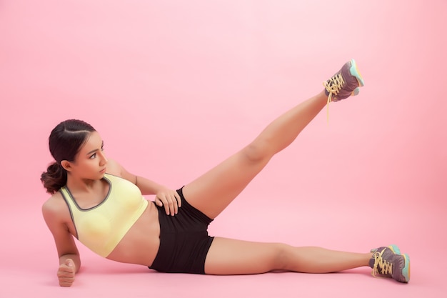 Beautiful healthy young Asian woman doing a stretching exercise before playing a sport.