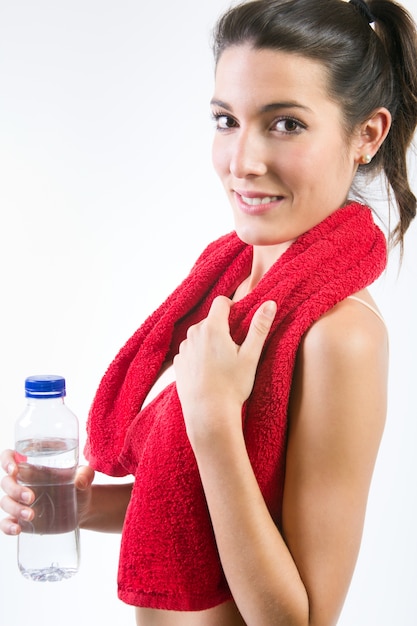 Beautiful healthy young woman drinking water after exercise