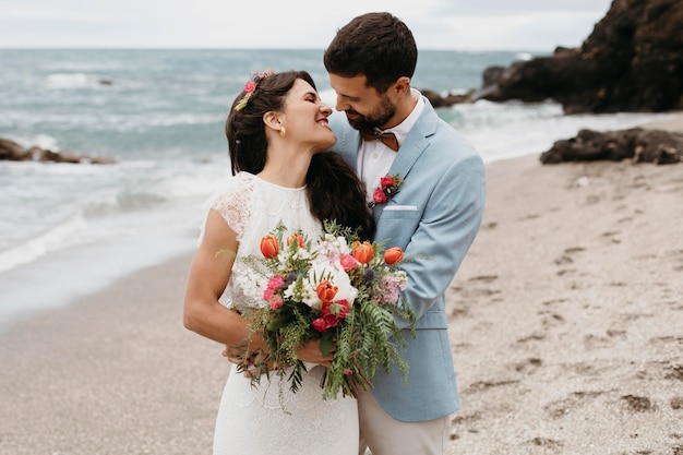 Beautiful husband and wife posing on the beach