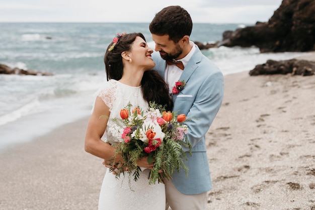ビーチでポーズをとる美しい夫と妻