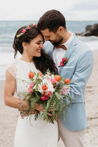 ビーチでポーズをとる美しい夫と妻