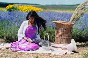 Foto gratuita la bella ragazza indiana indossa l'abito tradizionale saree india nel campo di lavanda viola con cesto