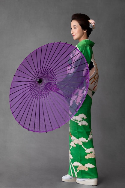 紫色の傘を持つ美しい日本のモデル