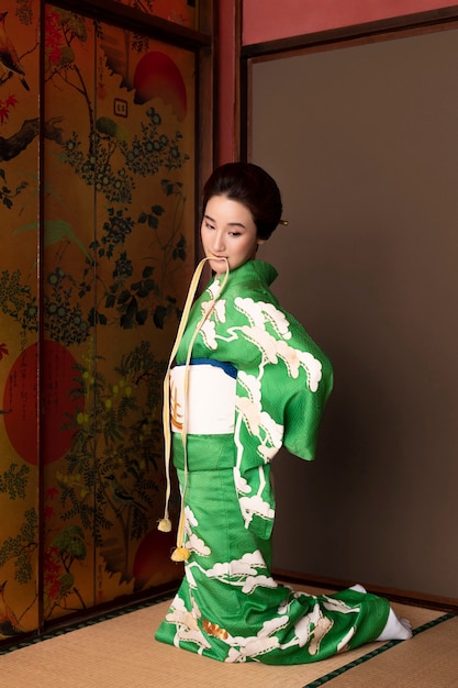 Beautiful japanese woman putting on an obi