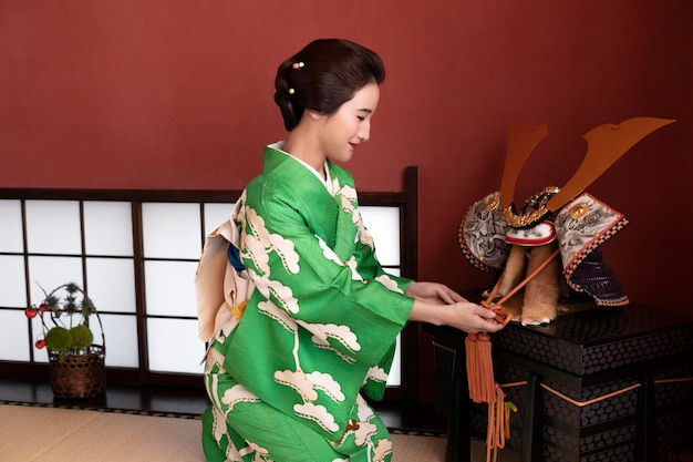 Foto gratuita bella donna giapponese accanto a un oggetto tradizionale