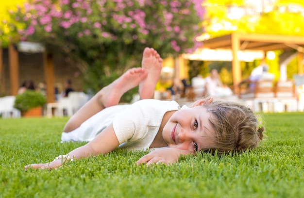 공원에서 잔디에 포즈를 취하는 아름다운 아이