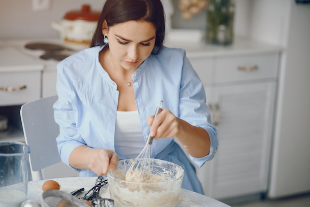 美しい女性はクッキーの生地を調理する