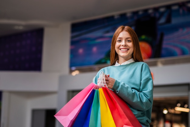 カラフルな買い物袋を保持している美しい女性