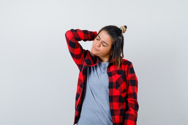 Beautiful lady holding hand behind head in casual clothes and looking tired. front view.