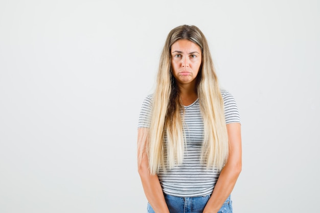 Beautiful lady looking at front in t-shirt and looking upset , front view.