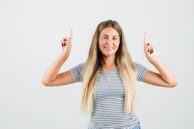 Tシャツで上向きに幸せそうに見える美しい女性。正面図。