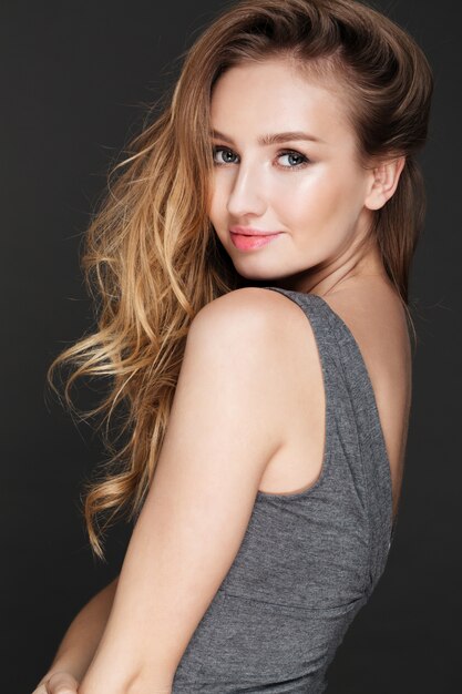 Beautiful lady posing over dark wall