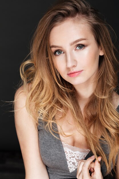 Beautiful lady posing over dark wall