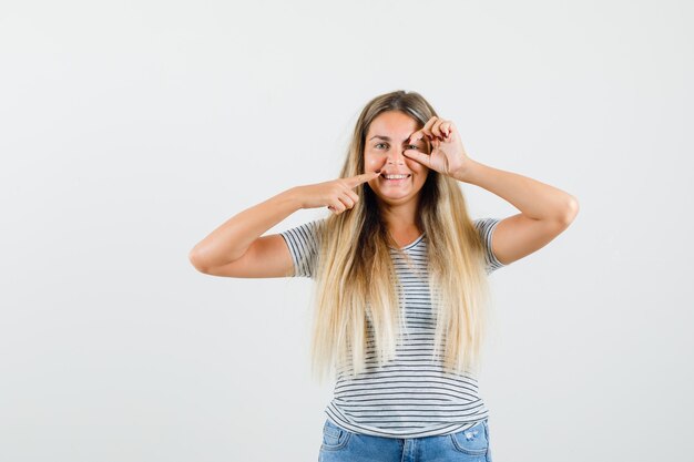 Tシャツで彼女の歯を見せて、狂ったように見える美しい女性、正面図。