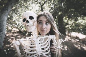 Free photo beautiful lady behind skeleton