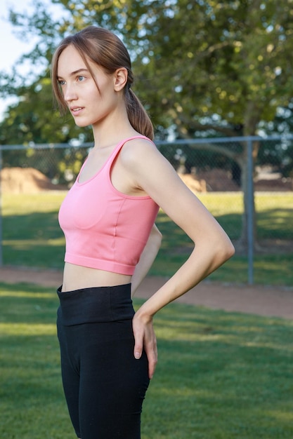 Beautiful lady standing at the park and looking to the camera