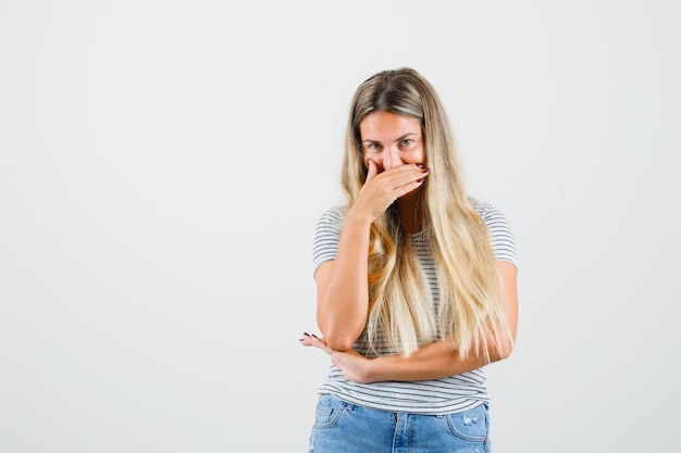 Beautiful lady in t-shirt laughing secretly and looking cute , front view.