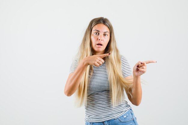 脇を向いて注意深く見ているTシャツの美しい女性、正面図。