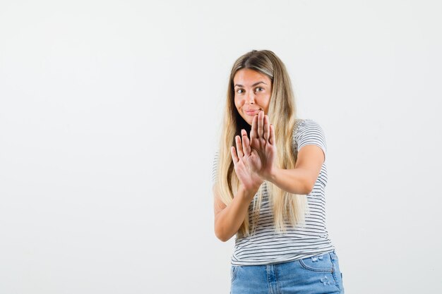 Beautiful lady in t-shirt rejecting something and looking shy , front view.