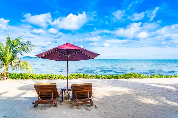 흰 구름과 푸른 하늘 빈 의자 갑판과 우산 거의 코코넛 야자 나무와 해변 바다 바다의 아름다운 풍경