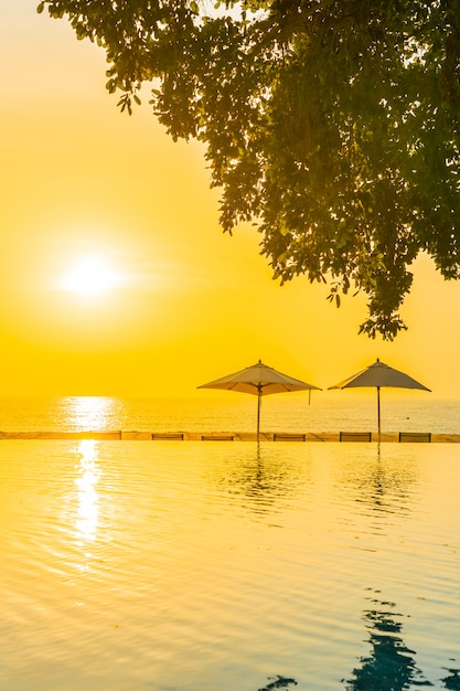 Beautiful landscape outdoor swimming pool with umbrella and deck chair in hotel resort for relax tra