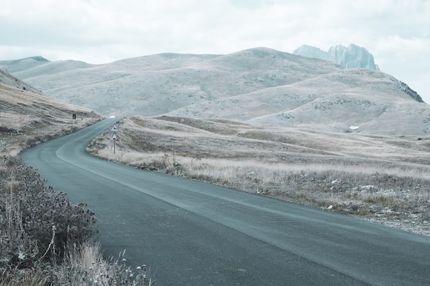 曇りの日に丘を転がる道の美しい風景