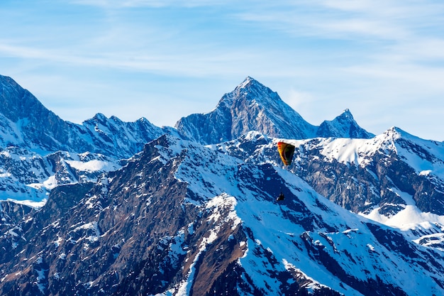 南チロル、ドロミテ、イタリアのパラグライダーと雪に覆われた山々の美しい風景