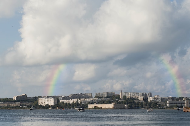 Free photo beautiful landscape with rainbow and city