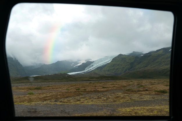 Foto gratuita bellissimo paesaggio con arcobaleno e montagne