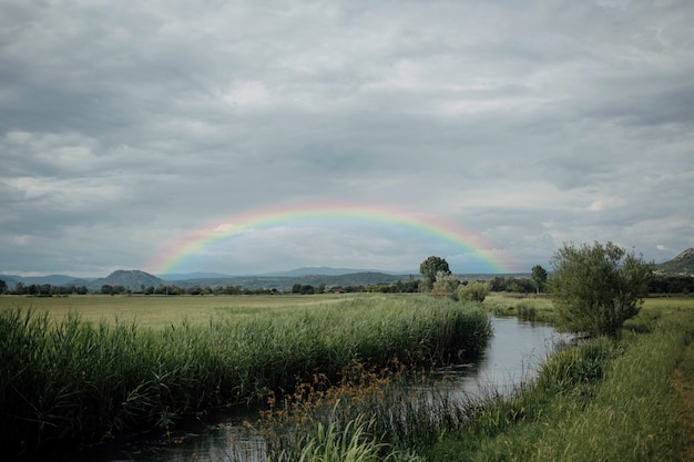 Bellissimo paesaggio con arcobaleno e fiume