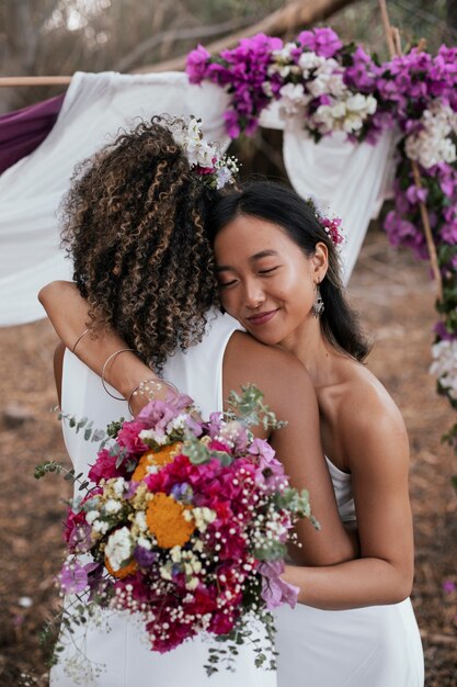 美しいレズビアンカップルが外で結婚式を祝っている