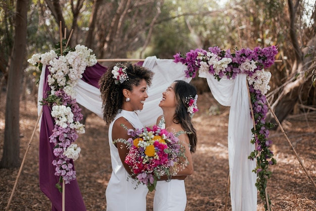 Foto gratuita una bella coppia lesbica che celebra il giorno del loro matrimonio all'aperto