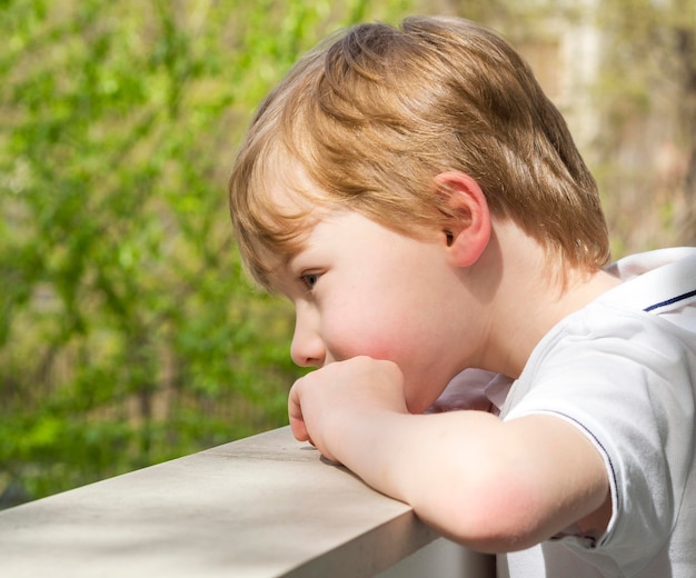 Beautiful little boy looking outside